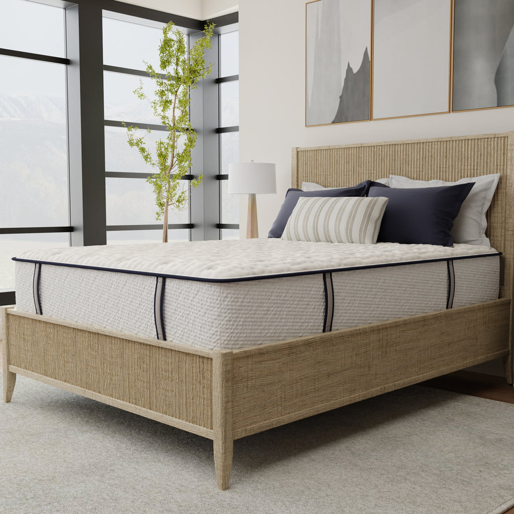 Bedroom with a bed featuring a mattress and pillows, wooden headboard, and large windows.