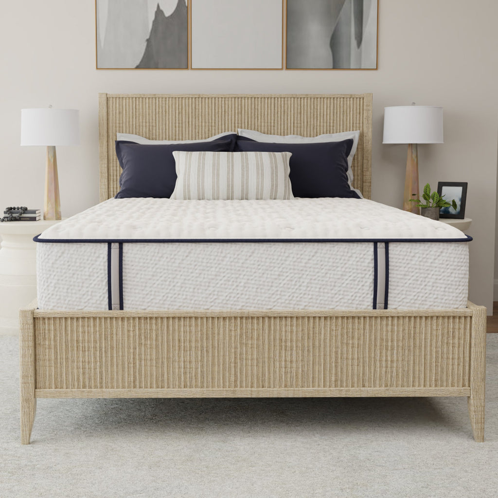 Bed with white mattress, beige headboard, and decorative pillows in a bedroom setting.