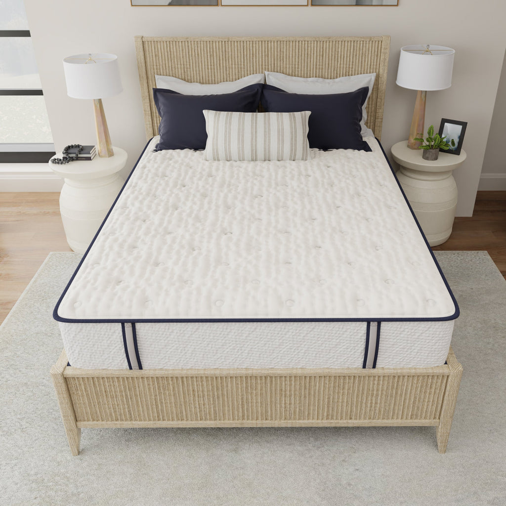 Mattress on a bed with wicker headboard and nightstands in a bedroom setting