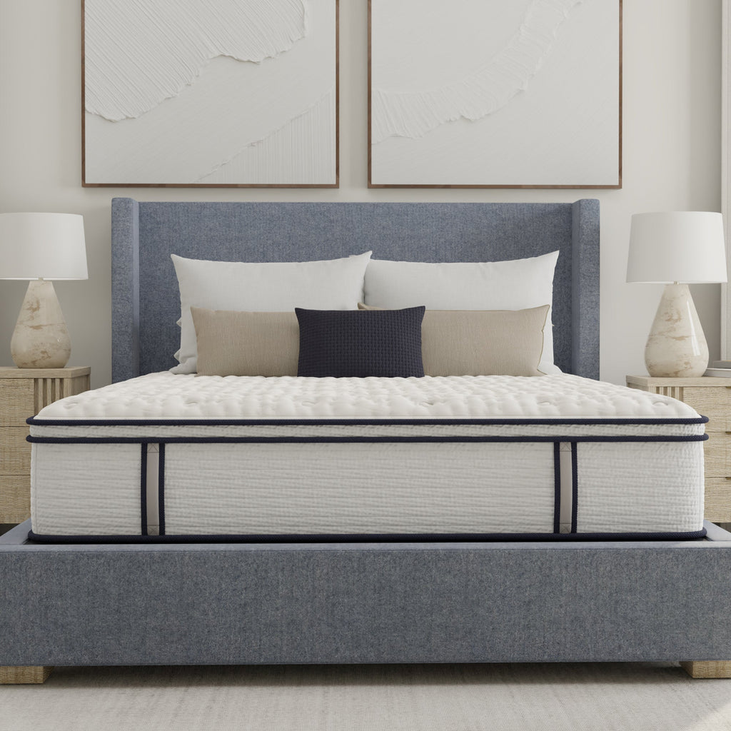 Mattress on a bed with pillows in a bedroom setting