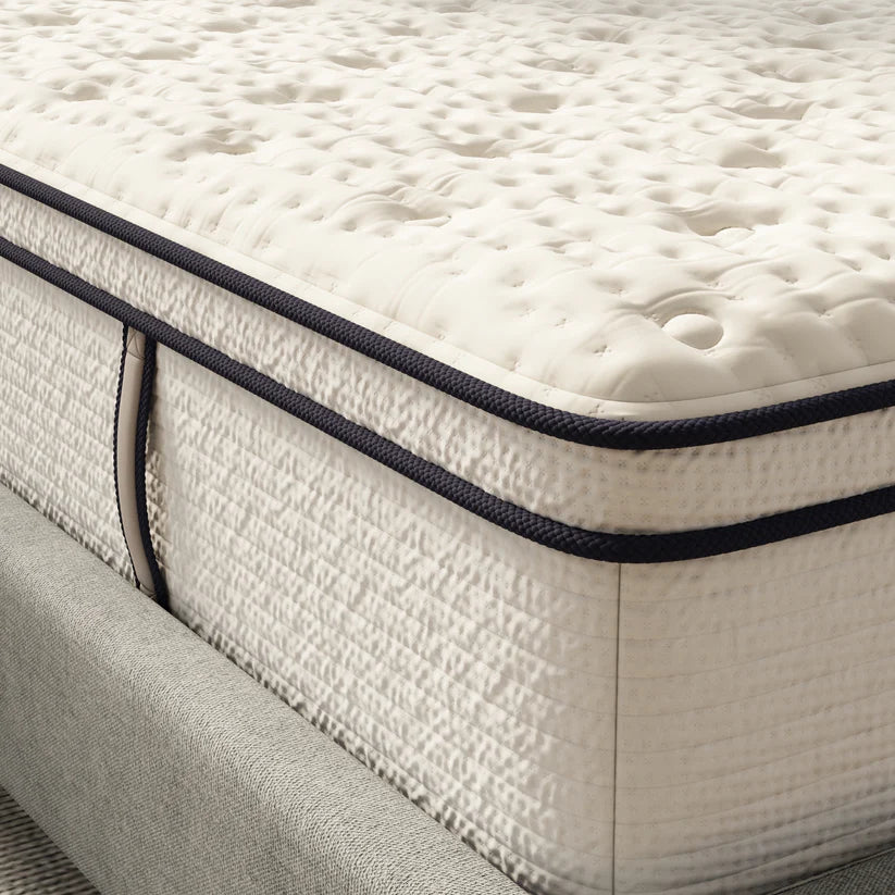 Close-up of a mattress with a textured surface and dark blue border.
