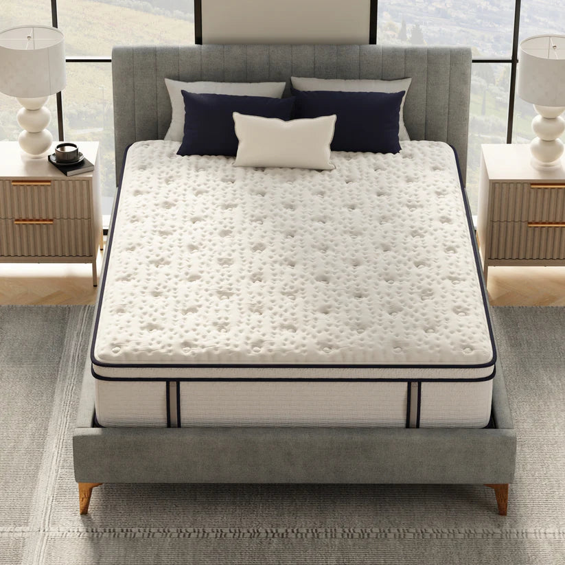 Mattress on a bed with pillows in a bedroom setting