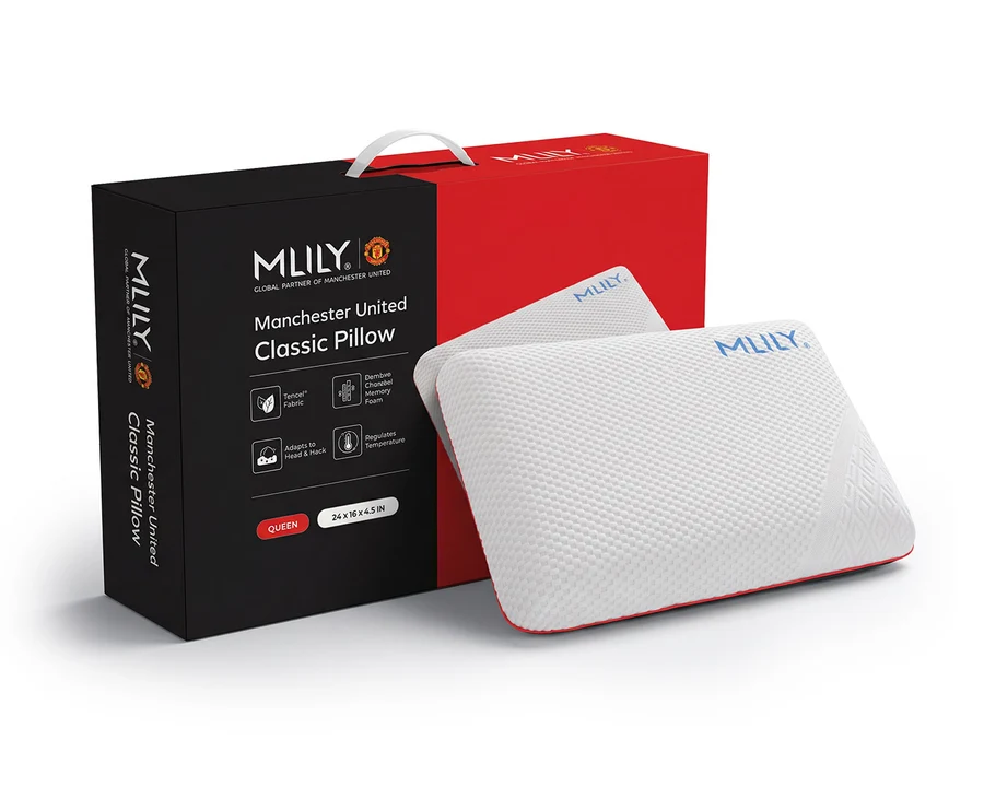 A white textured classic pillow with blue 'MILY' branding, shown in front of its black and red retail packaging box on a clean white background.