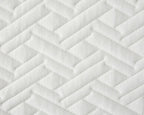 A close-up of a white quilted fabric with a geometric, zigzag pattern stitched into padded rectangular sections.
