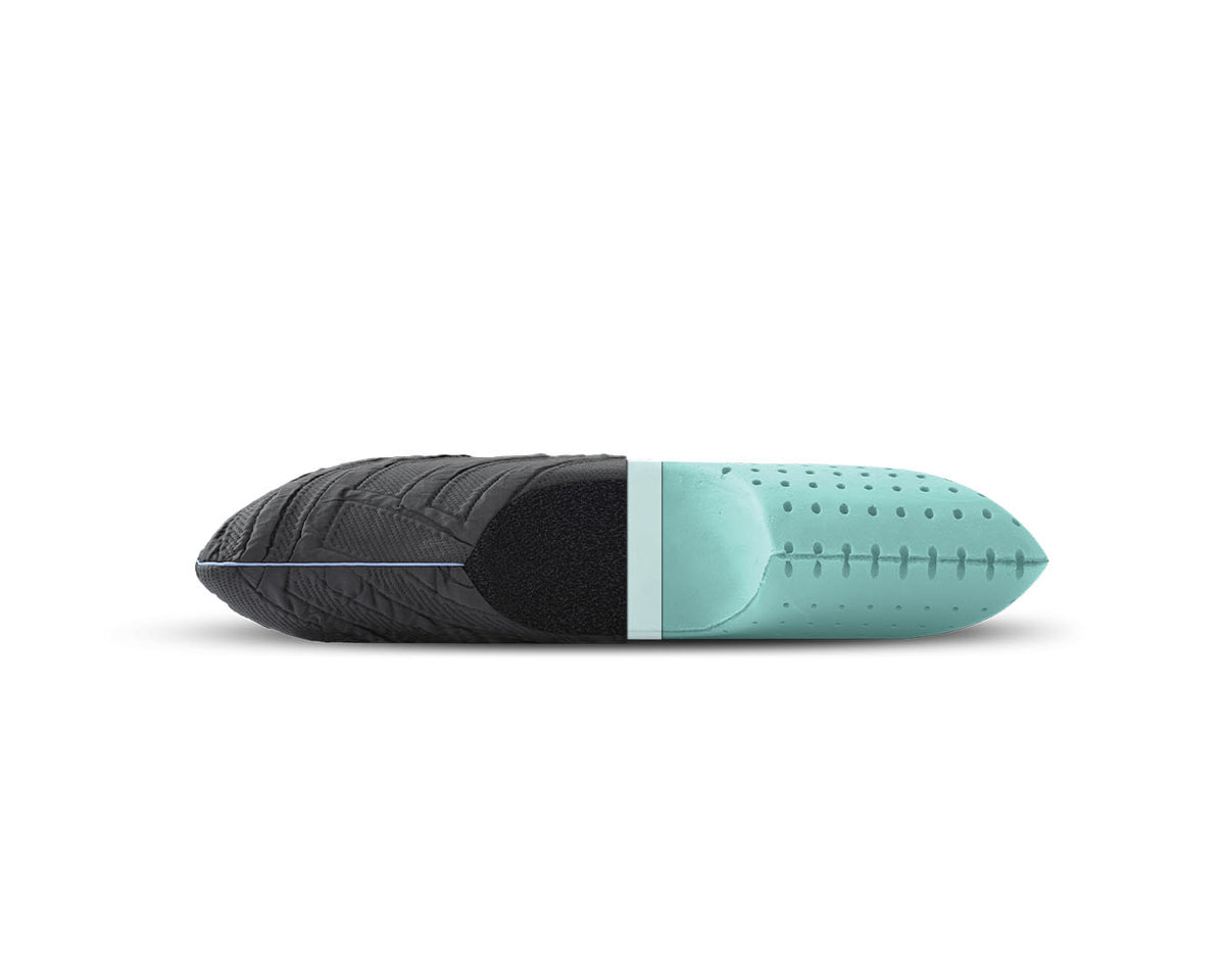 A capsule-shaped sleep support pillow with a textured black exterior and a mint green interior, shown horizontally on a white background.