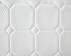 Close-up of a white quilted mattress or cushion surface with stitched octagonal and diamond panels and a textured fabric pattern.